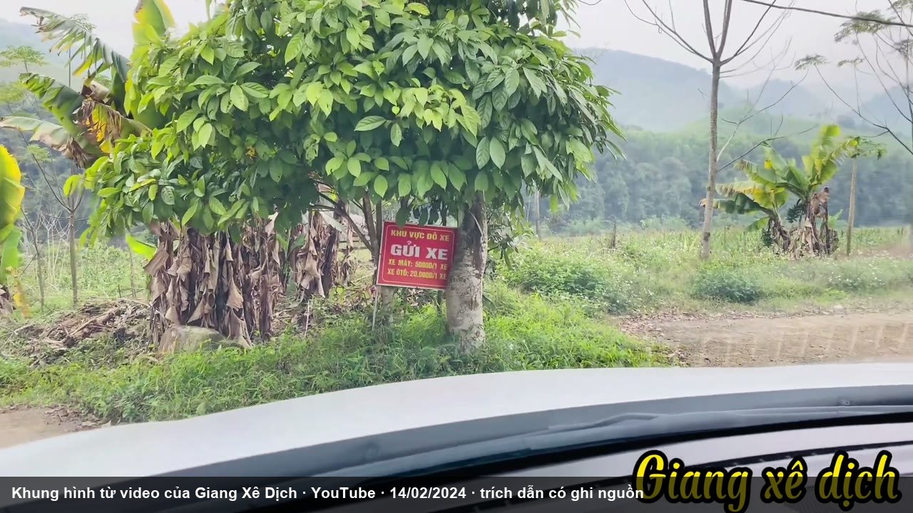 Biển chỉ dẫn gửi xe ở lối vào thác, nhìn từ xe (Giang Xê Dịch, YouTube, 14/02/2024, mốc 2 phút 21)